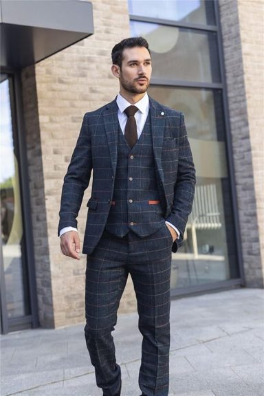 Man in a stylish check-patterned suit, walking confidently outdoors.